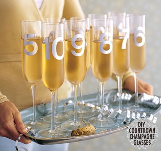 Make countdown champagne glasses by spray-painting numbers on them.: 